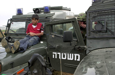 Palestinian boy tied to an Israeli military vehicle.